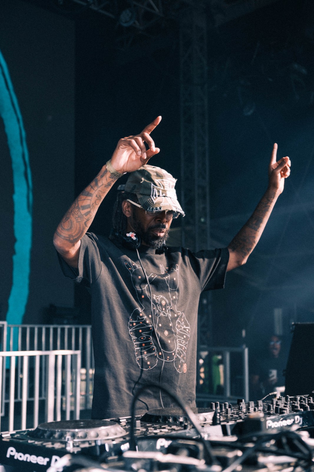 DJ raising both hands behind the decks at Big Smoke.