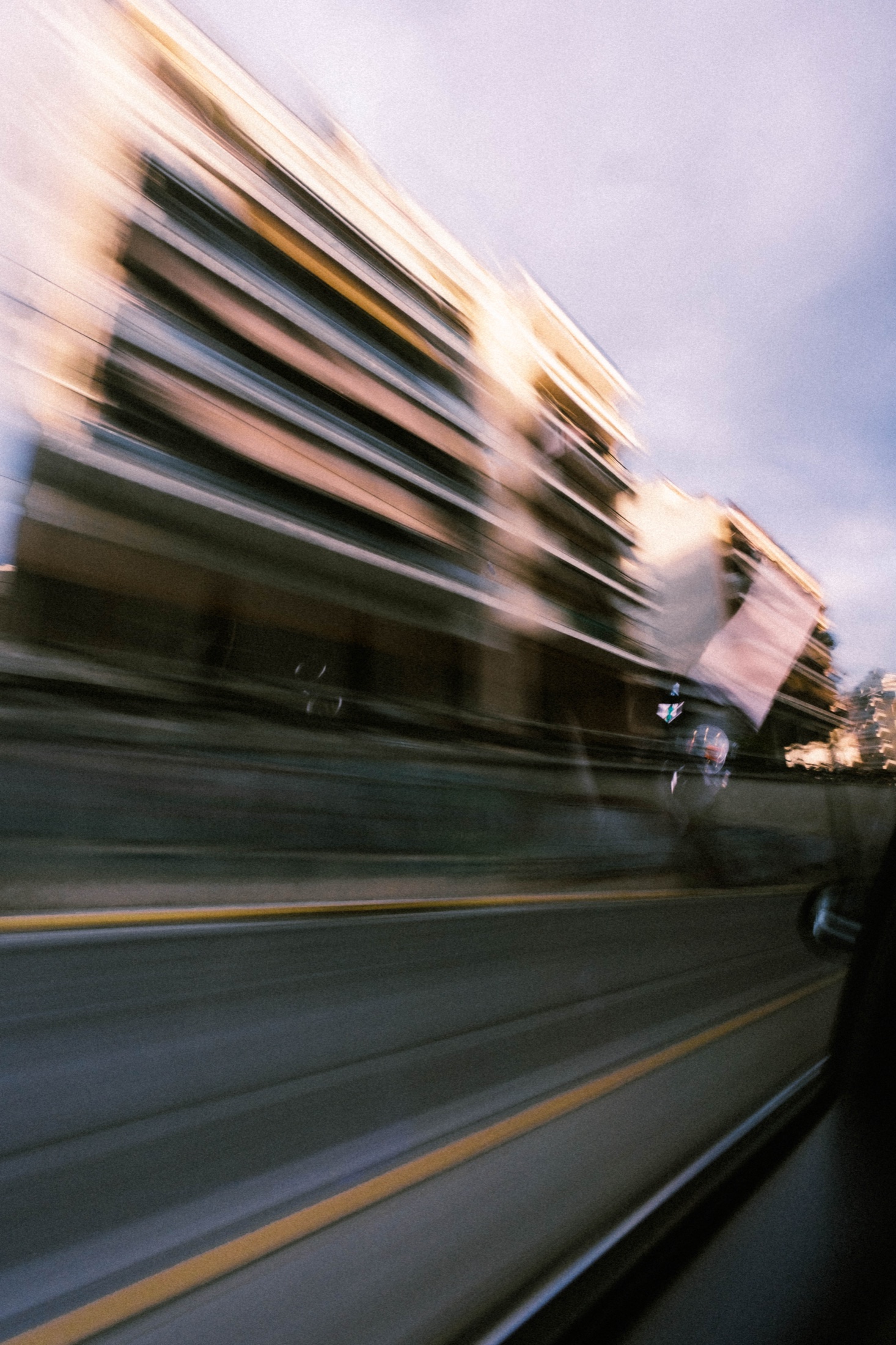 City buildings blurred through the window of a moving car.