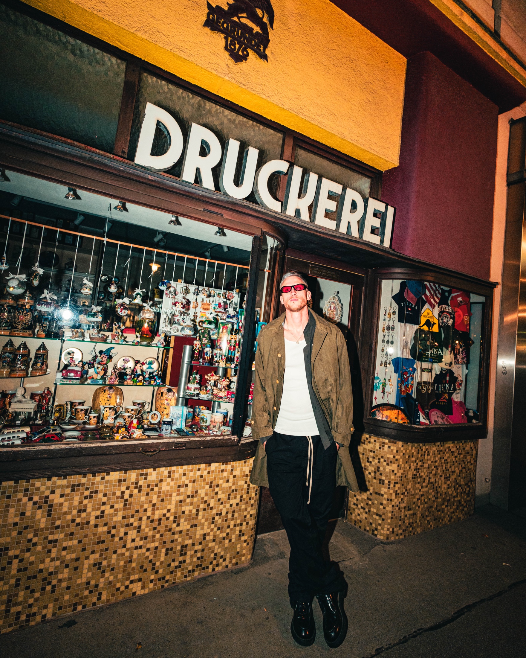 Eli Brown posing outside a shop window at night.