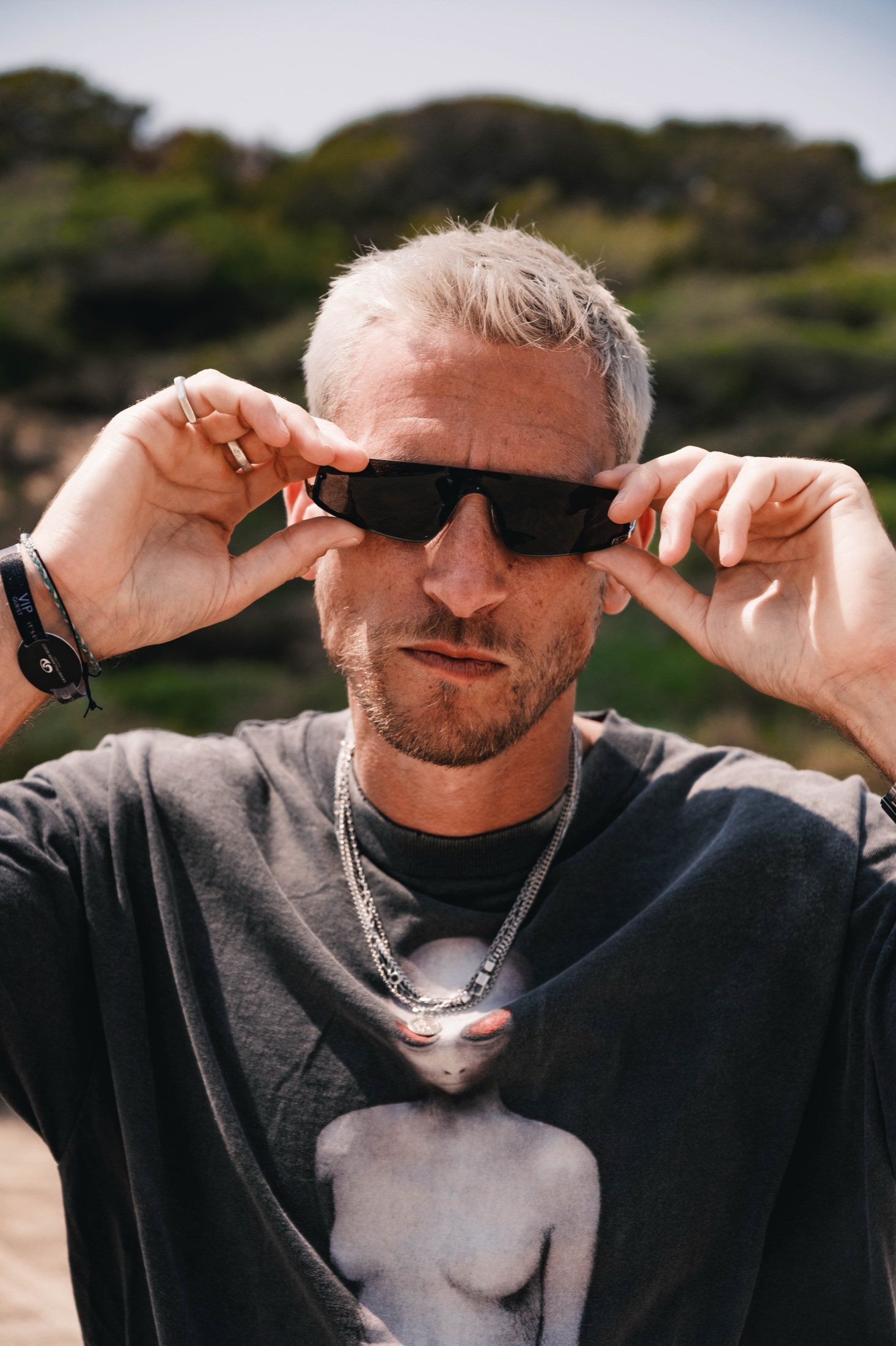 Eli Brown adjusting his sunglasses during an outdoor portrait.