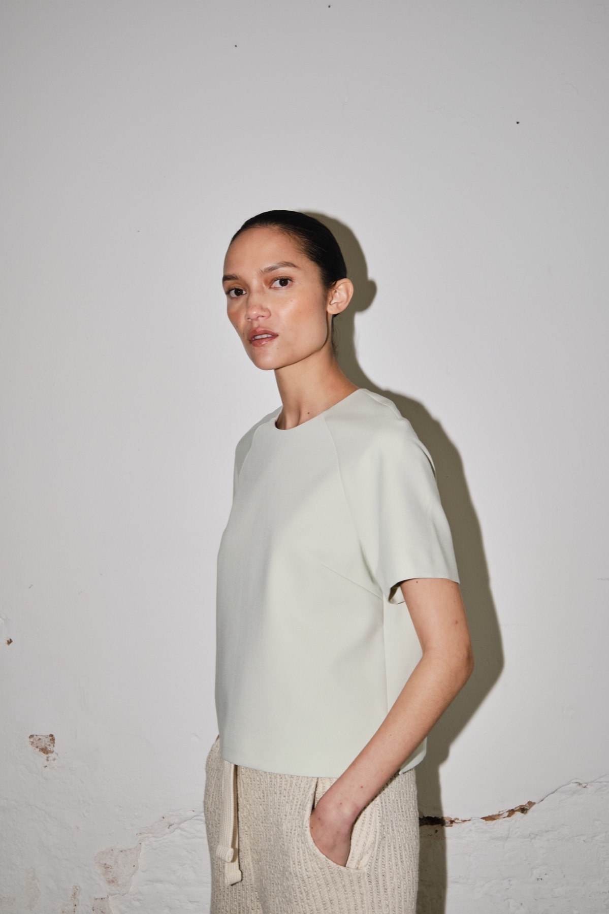 Emello SS26 model in a light neutral look against a studio wall