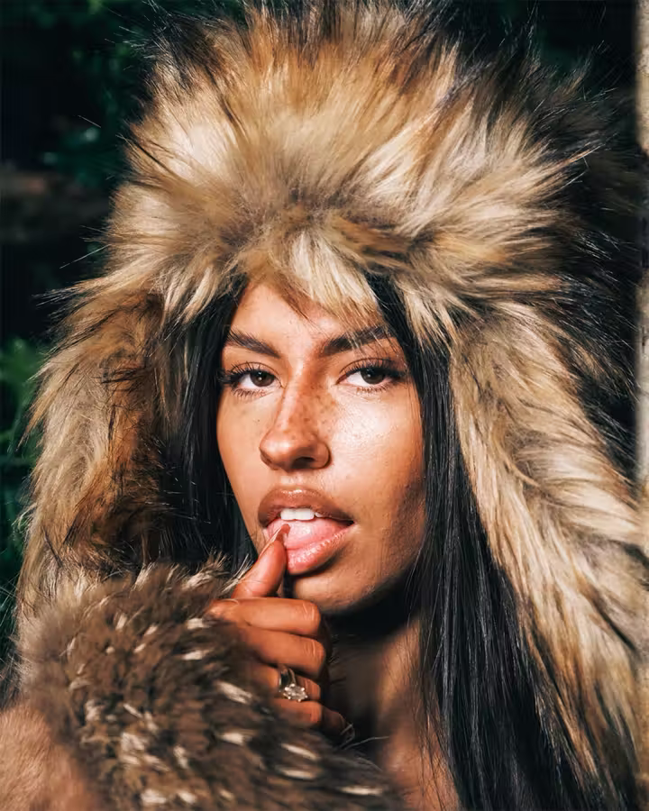 OYE portrait framed by a hood with fur trim