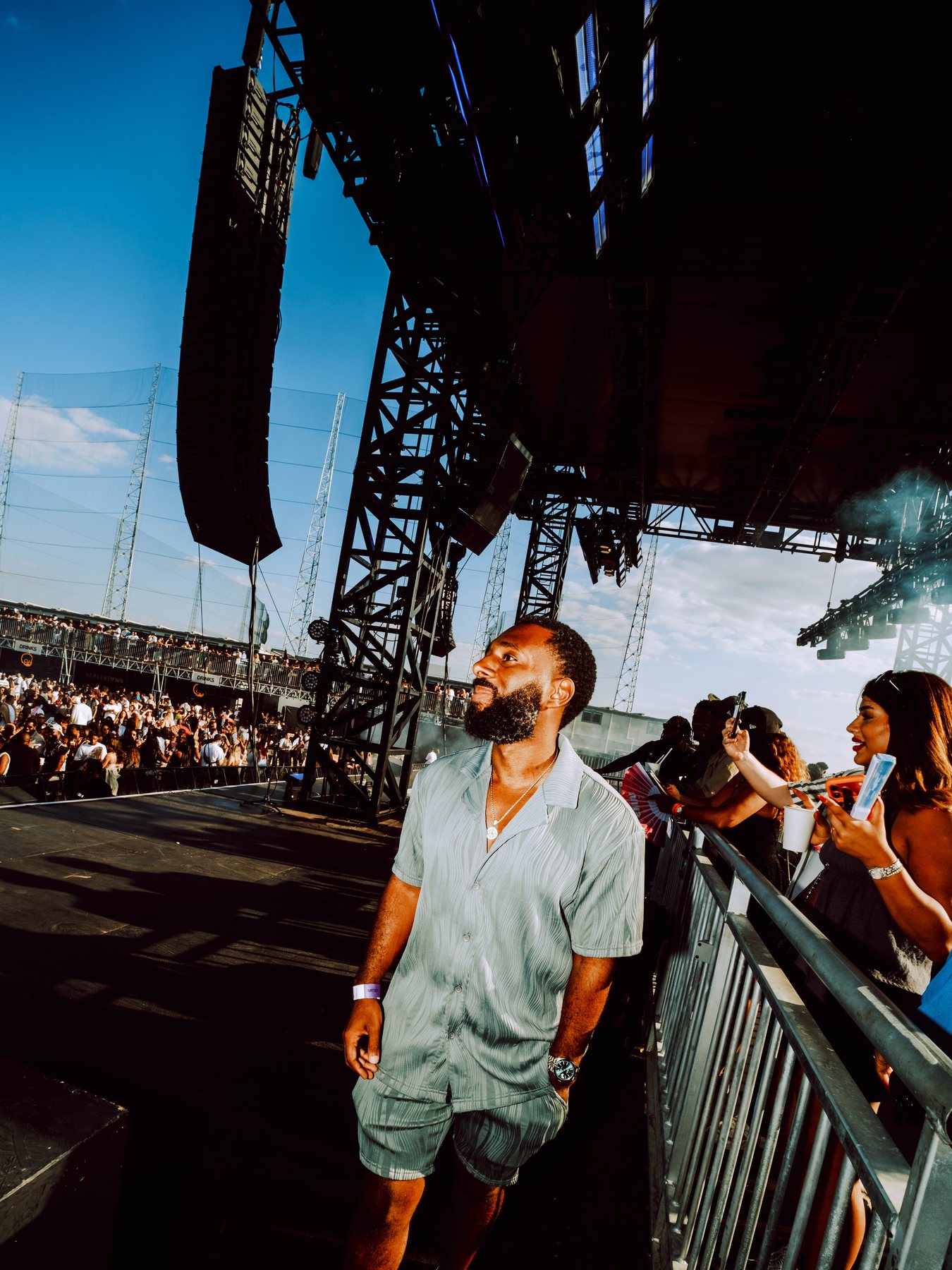 Attendee walking beside the stage as the R&B Slow Jams crowd gathers in daylight.