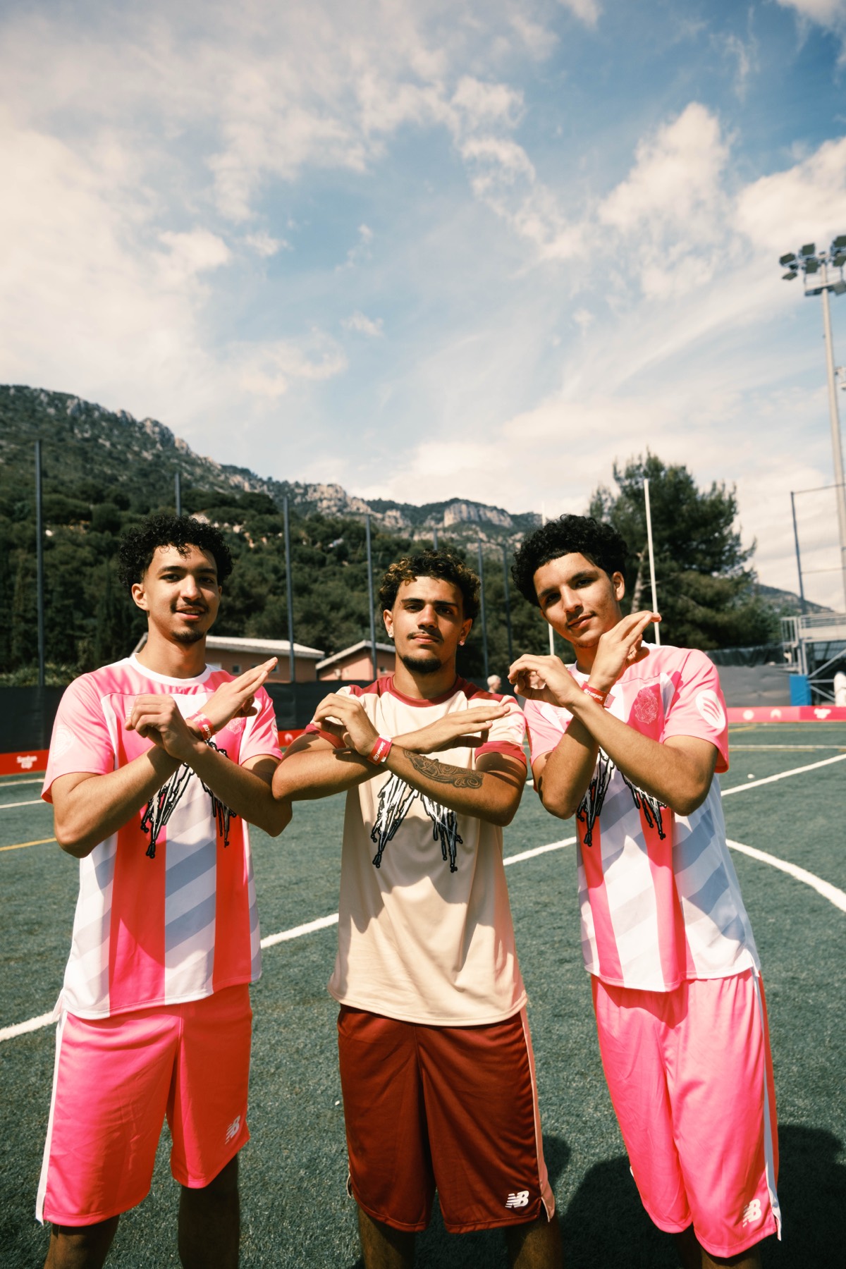 Three Santan Cup players posing together on the football pitch.