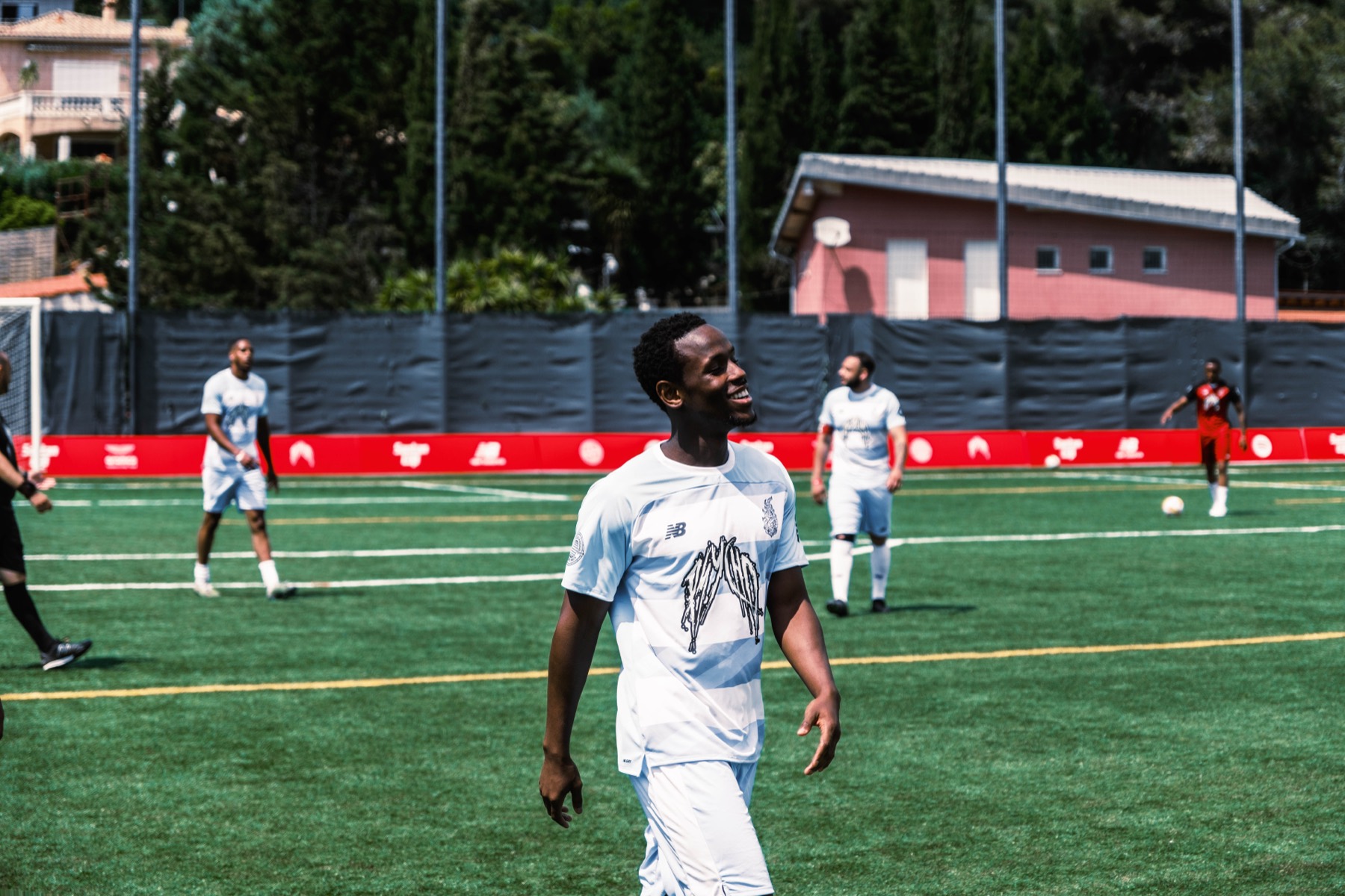 Smiling player walking across the pitch during Santan Cup.