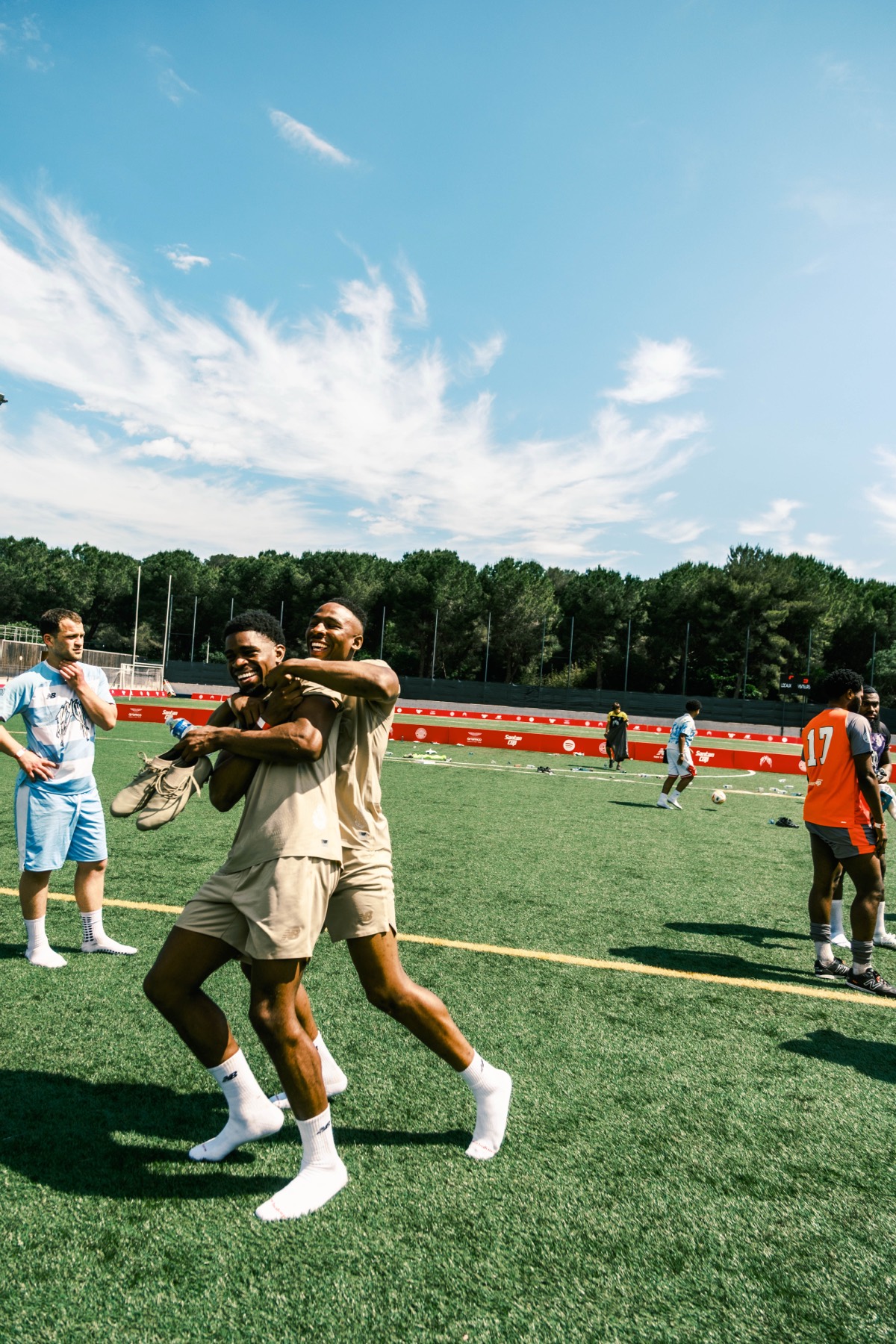 Two Santan Cup players celebrating together on the pitch.
