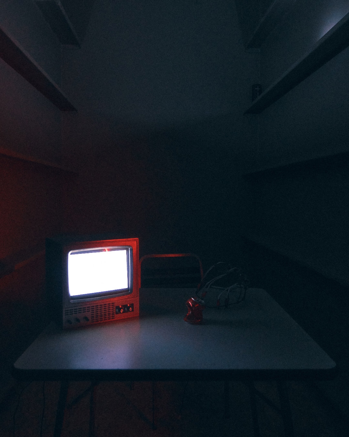 Small vintage television glowing in a dark room