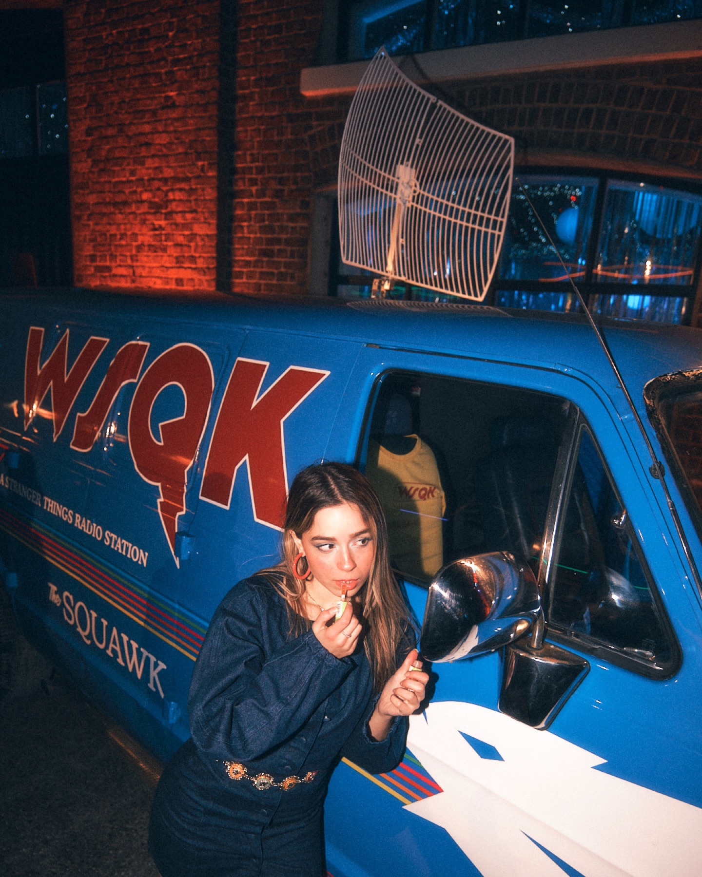 Guest leaning from the window of the themed WSQK radio van